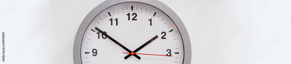 Simple modern wall clock in silver color frame, isolated on white background.House Interior .big round clock hanging on a wall. copy space, deadline,time management concept and lunch time.web banner. Simple modern wall clock in silver color frame, isolated on white background.House Interior .big round clock hanging on a wall. copy space, deadline,time management concept and lunch time.web banner.