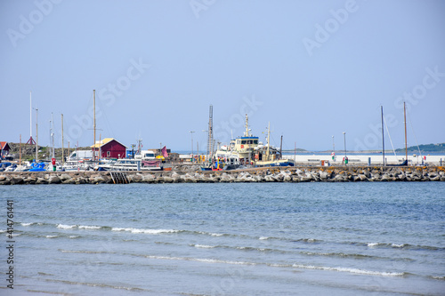 Sandbank, shallow waves and panoramic views of the port and moored yachts, Torekov, Sweden. photo