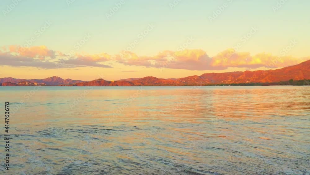 Sea water wave hit sand beach, mountain long distance, beautiful golden sky. High quality 4k footage Sea water wave hit sand beach, mountain long distance, beautiful golden sky. High quality 4k footage