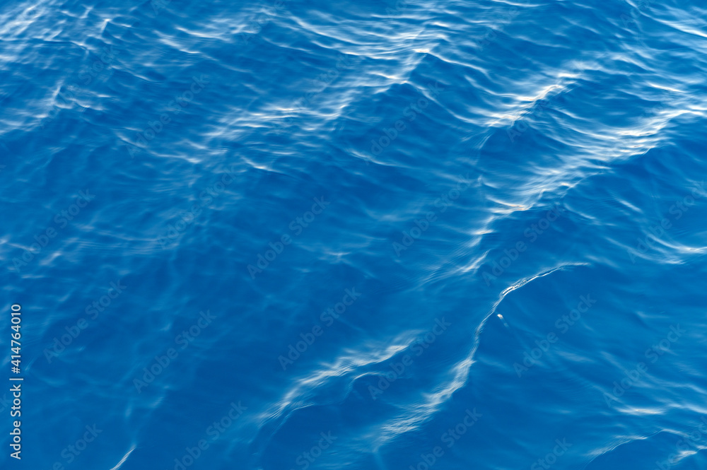 Sea surface. Blue water texture. Close up blue water surface at deep ocean Sea surface. Blue water texture. Close up blue water surface at deep ocean