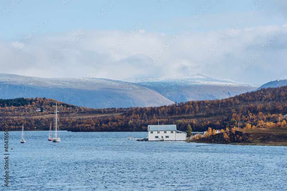 Biały dom na wodzie w jesiennym krajobrazie