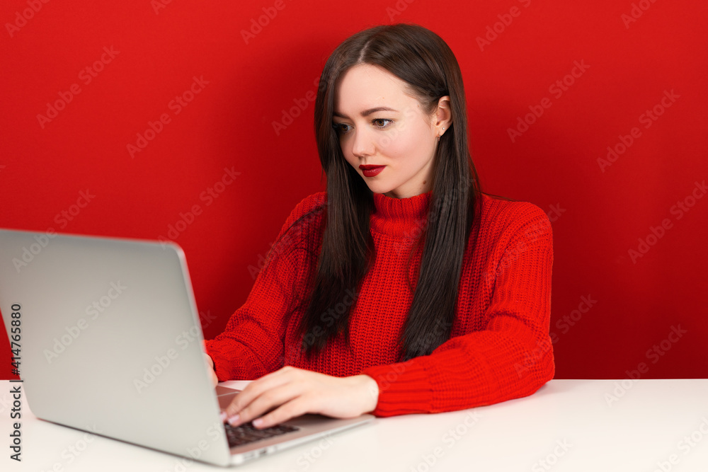beautiful girl at the computer on a red background beautiful girl at the computer on a red background