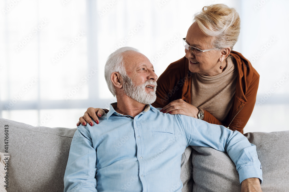 Happy mature couple sitting on sofa and communicating Happy mature couple sitting on sofa and communicating