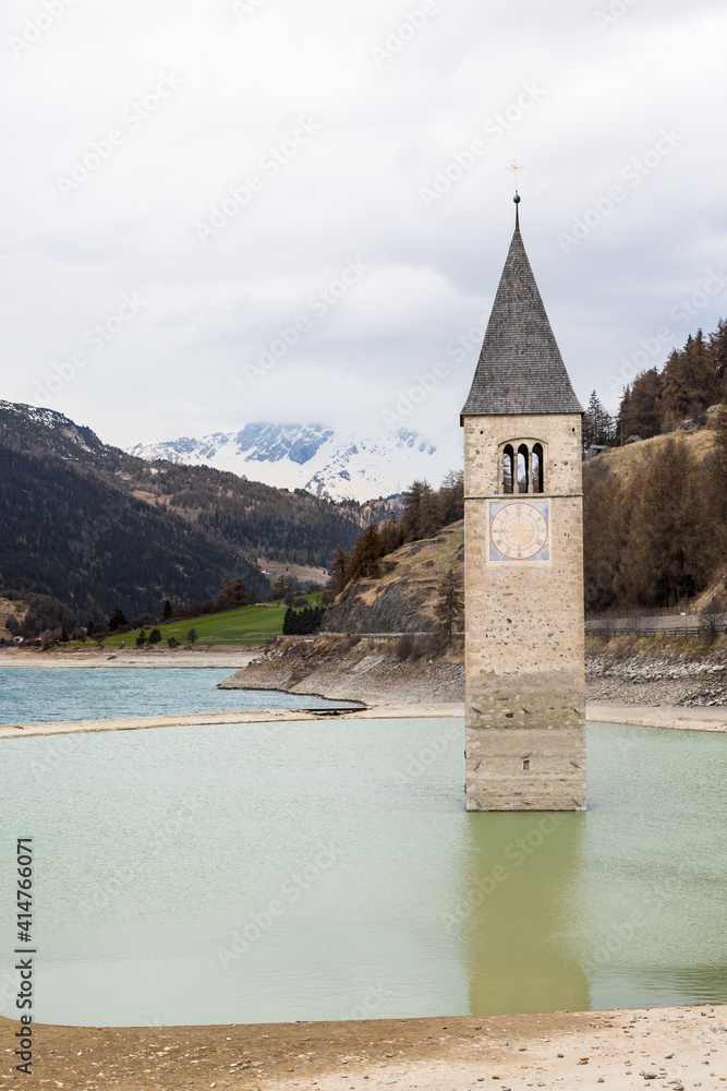 Close up of the iconic sunken bell tower of Curon surrounded by the water of Resia lake