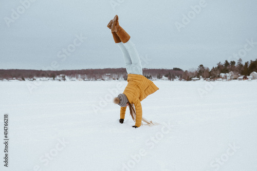 A woman doing a handstand in the snow photo