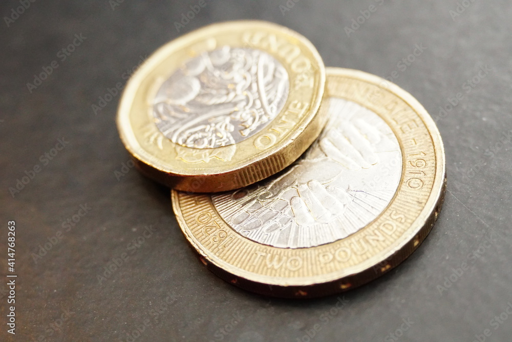 Macro closeup of one pound and two pound coins on top of each other. Macro closeup of one pound and two pound coins on top of each other.