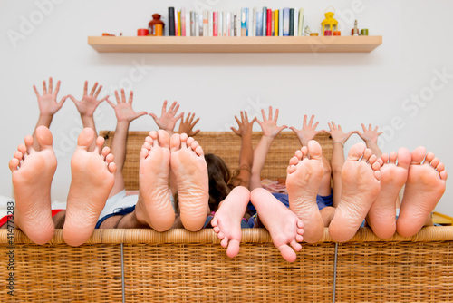 Simpatica famiglia sul letto mostra mani e piedi photo