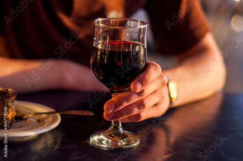 A glass of dessert red wine in the hands of the winemaker