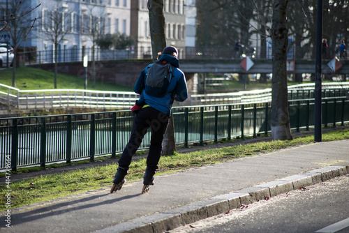 Portrait on back view of man on roller blade in the street