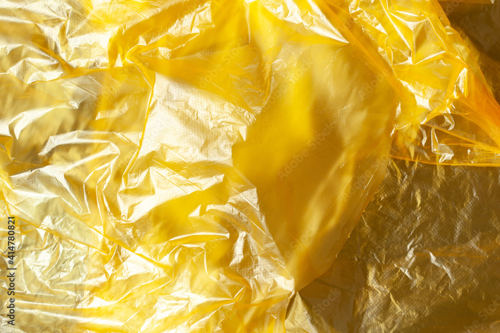 Background, texture from yellow recyclable polyethylene. Eco, zero waste, alternative to plastic concept. Flat lay. Horizontal. Close-up. For eco blog Background, texture from yellow recyclable polyethylene. Eco, zero waste, alternative to plastic concept. Flat lay. Horizontal. Close-up. For eco blog