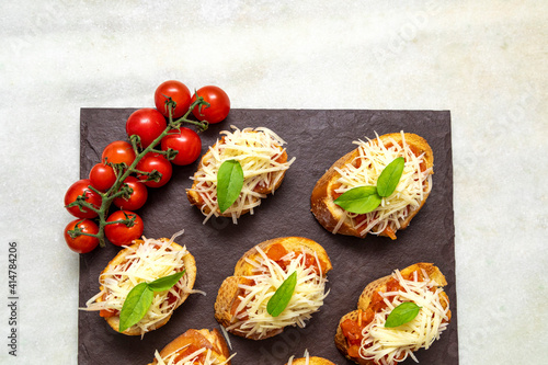 bruschetta toasts with cherry tomatoes, mozzarella and basil. Top view with space for your text