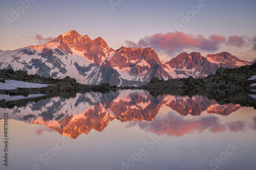 Clouds and Peaks at Dawn Reflected in the Frati Lake, Italian Alps, Valcamonica, Lombardy, Italy  photo