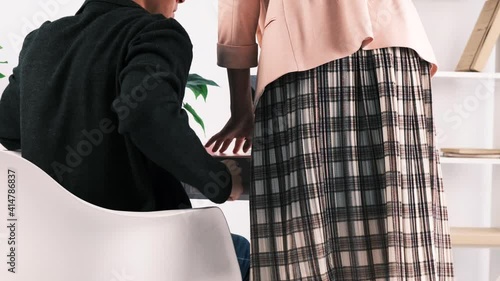 Harassment at work, subordinate and boss. Young male boss sexually assaults his secretary, grabbing her ass when she brought him documents to his desk. Woman breaks free and runs away. Back view, 4k