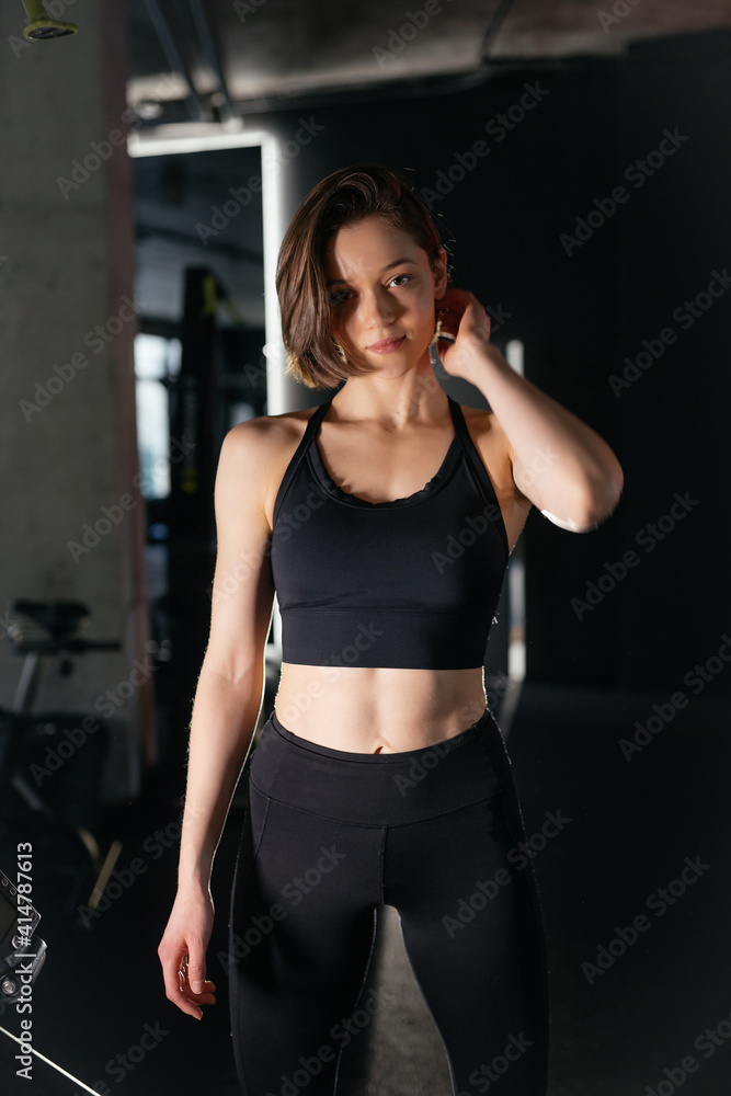 Portrait of Confident Brunette Woman Wearing Performance Wear in Gym