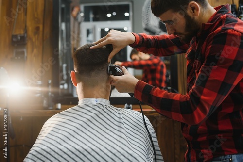 Serious Young Bearded Man Getting Haircut By Barber. Barbershop Theme