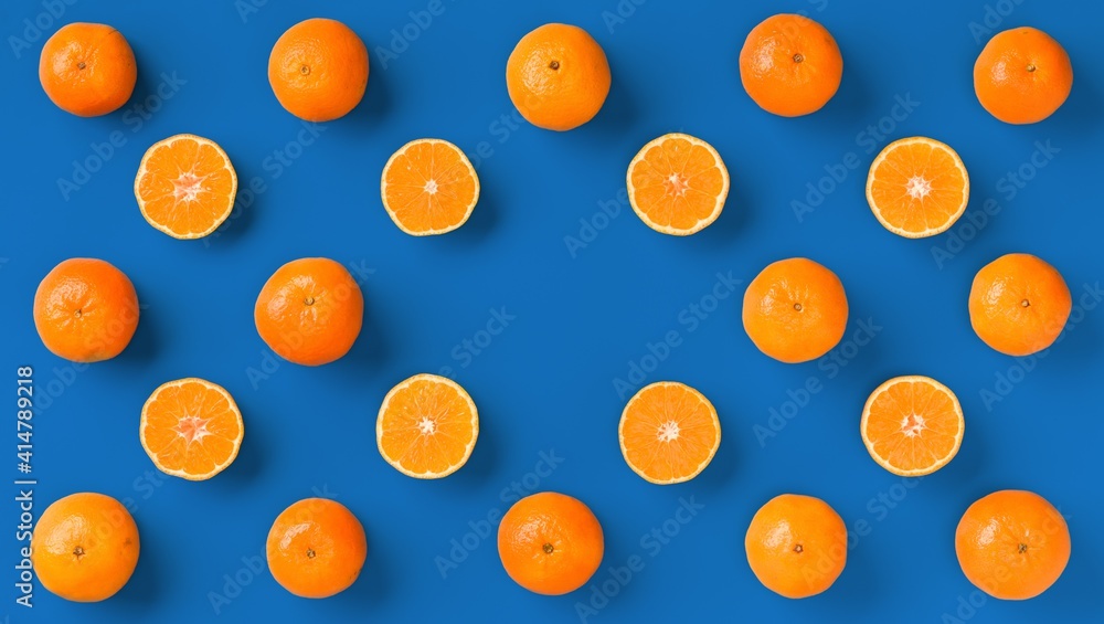 Fruit pattern of fresh orange tangerine or mandarin on blue background. Flat lay, top view. Pop art design, creative summer concept. Citrus in minimal style. Fruit pattern of fresh orange tangerine or mandarin on blue background. Flat lay, top view. Pop art design, creative summer concept. Citrus in minimal style.
