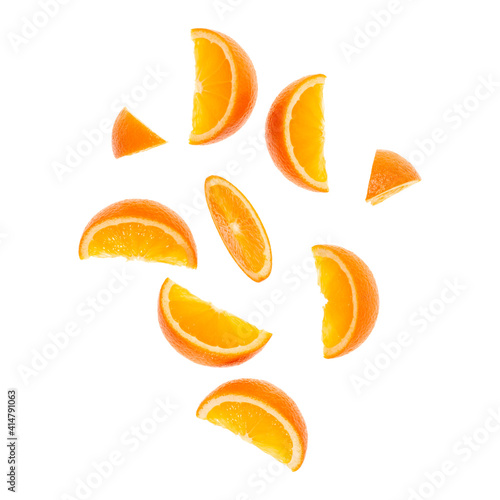 falling fresh orange fruit slices isolated on white background closeup. Flying food concept.