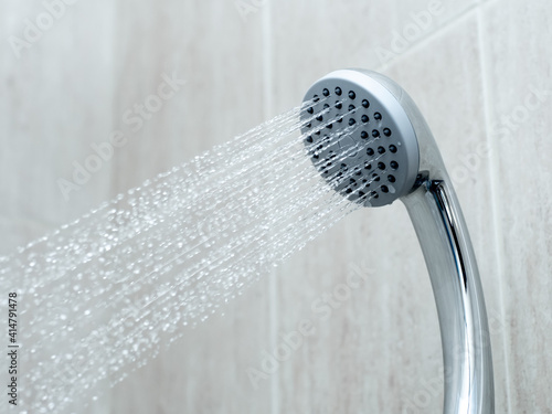 Shower head with water stream in the bashroom. Clean shower photo