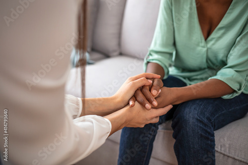 African psychologist hold hands of girl patient  close up. Teenage overcome break up  unrequited love. Abortion decision. Psychological therapy  survive personal crisis  individual counselling concept