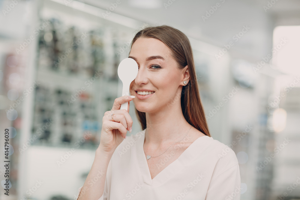 Portrait of happy young woman during eye exam at optometrist optician Portrait of happy young woman during eye exam at optometrist optician