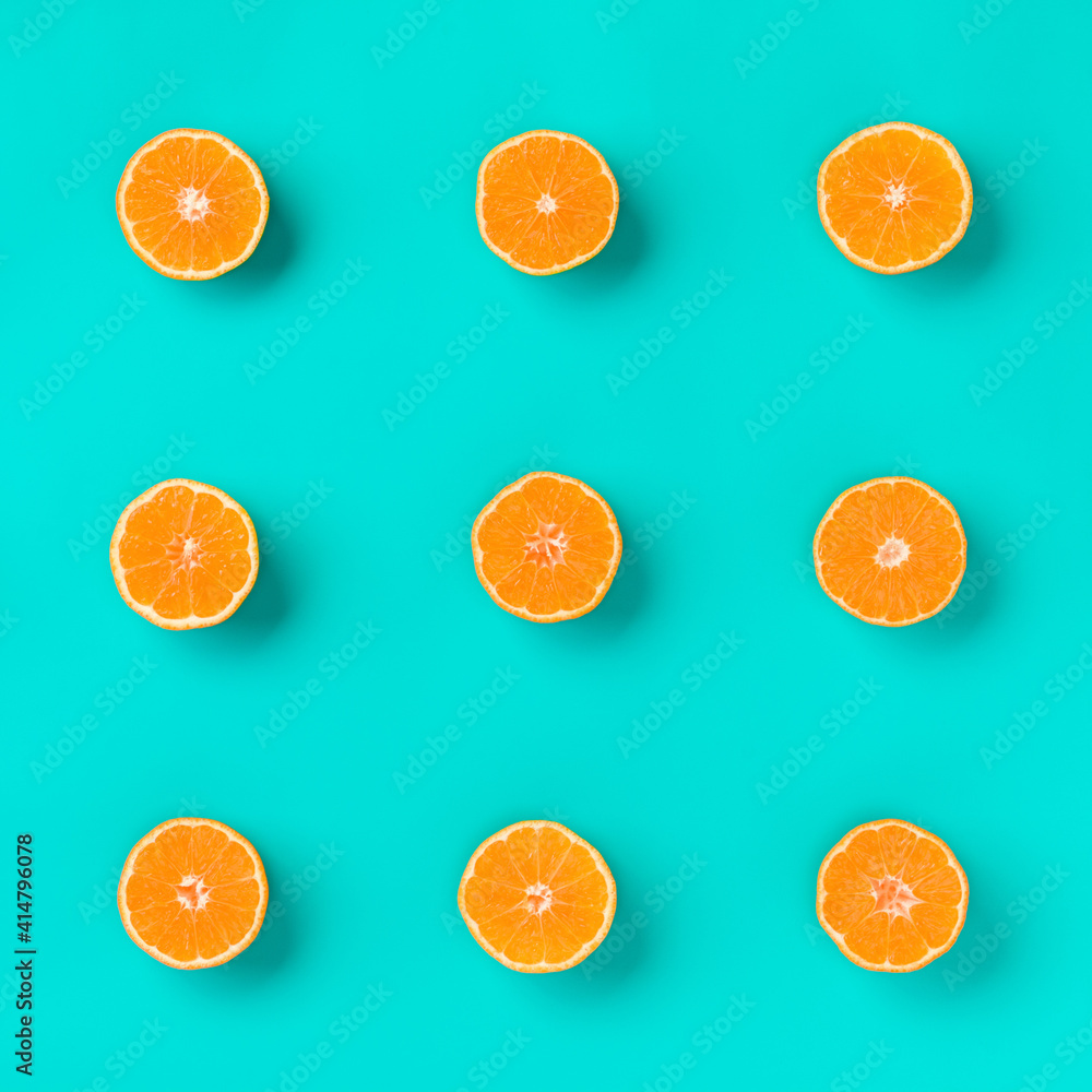 Fruit pattern of fresh mandarin slices on blue background. Flat lay, top view. Pop art design, creative summer concept. Half of citrus in minimal style. Tangerine. Fruit pattern of fresh mandarin slices on blue background. Flat lay, top view. Pop art design, creative summer concept. Half of citrus in minimal style. Tangerine.