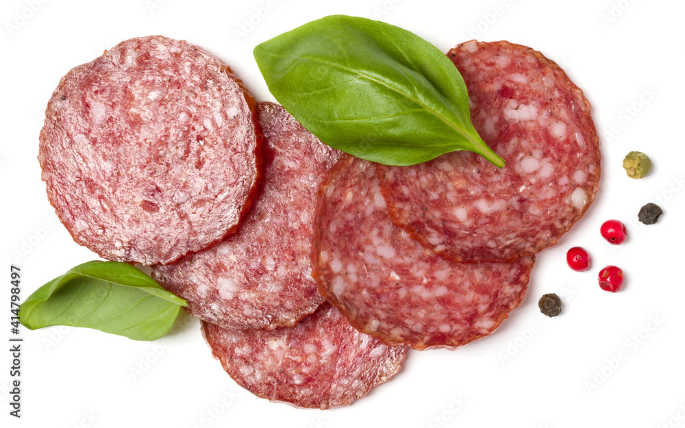 Slices of salami isolated on white background closeup. Sausage and basil leaves top view. Slices of salami isolated on white background closeup. Sausage and basil leaves top view.