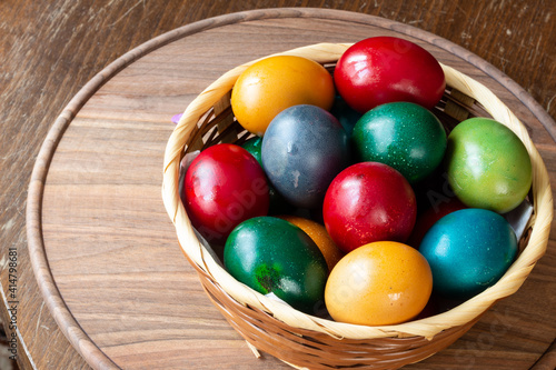 Easter eggs and Easter bun with flowers - wood background