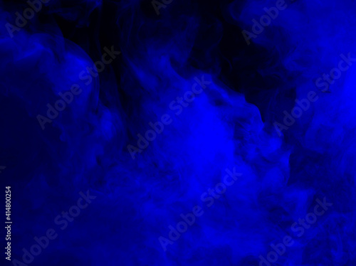 Abstract background of chaotically mixing puffs of blue smoke on a dark background