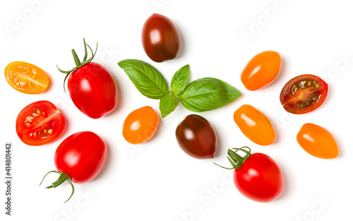 various colorful tomatoes and basil leaves isolated on white background. Top view, flat lay. Creative layout.