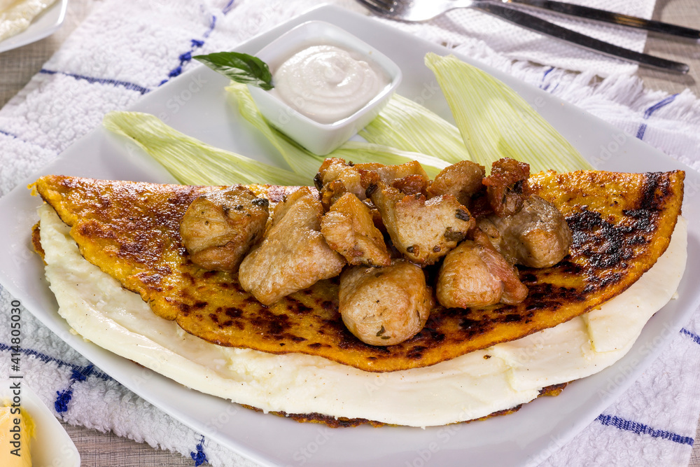 Fotografia do Stock: Comida típica de Venezuela servido en plato para  restaurante, cachapas con relleno de queso jamón, cochino frito