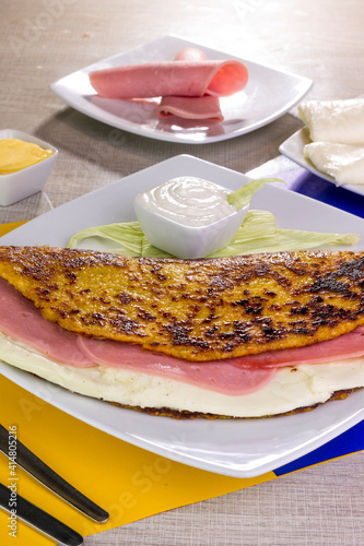 Comida típica de Venezuela servido en plato para restaurante, cachapas con relleno de queso jamón, cochino frito photo