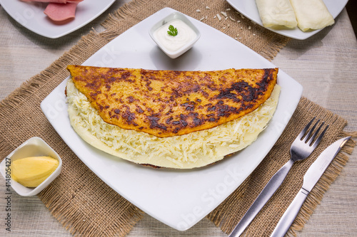 Comida típica de Venezuela servido en plato para restaurante, cachapas con relleno de queso jamón, cochino frito photo