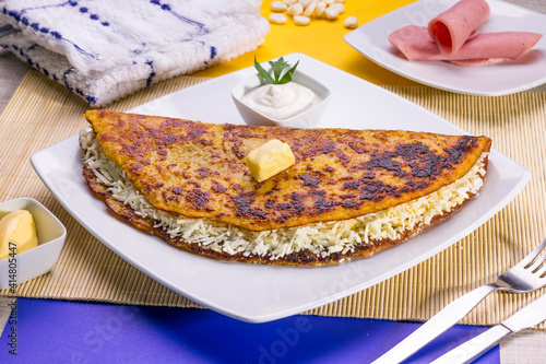Comida típica de Venezuela servido en plato para restaurante, cachapas con relleno de queso jamón, cochino frito photo