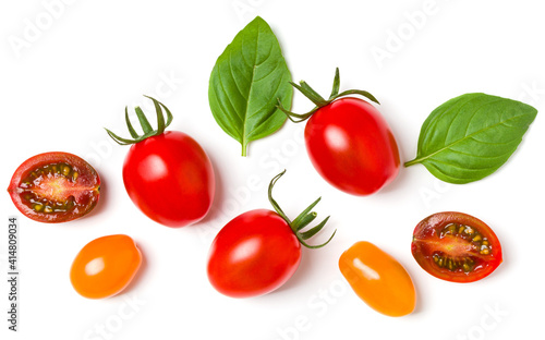 various colorful tomatoes and basil leaves isolated on white background. Top view, flat lay. Creative layout..