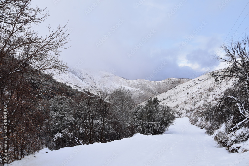 Snowy Hiking Trail views towards Lake Mountains Peak via Israel Canyon road towards Radio Towers in winter, Utah Lake, Wasatch Front Rocky Mountains, Provo, United States.