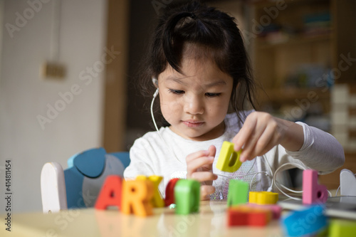 Asian girl learning alphabets online, Happy girl learn online with laptop at home. New normal. Covid-19 coronavirus. Social distancing. stay home