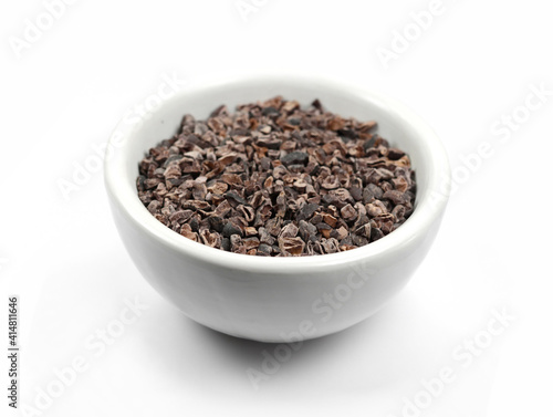 Cocoa nibs, a pieces of broken cocoa beans isolated on white background.