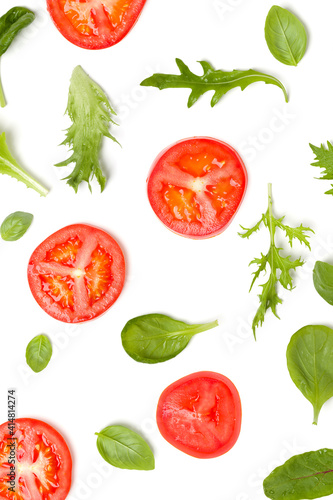 Vegetables background made of tomato slices and lettuce salad leaves. Flat lay, top view. Food concept. Vegetables isolated on white background. Food ingredients pattern.