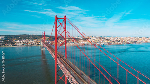 Drone photo of red 25 De Abril bridge in Lisbon which connecting Lisbon city and Almada across the Tagus river. Portugal sightseeing.
