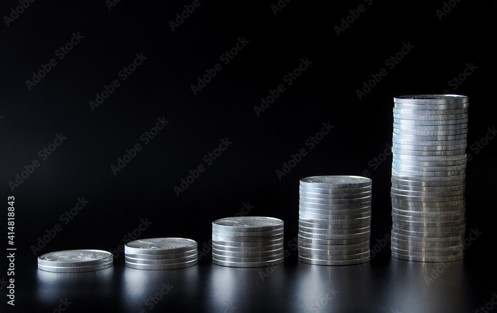 Stacks of silver coins of differing heights Stacks of silver coins of differing heights