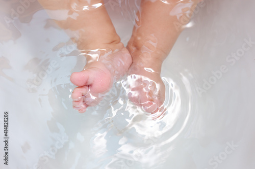 baby feet in a white bathtub