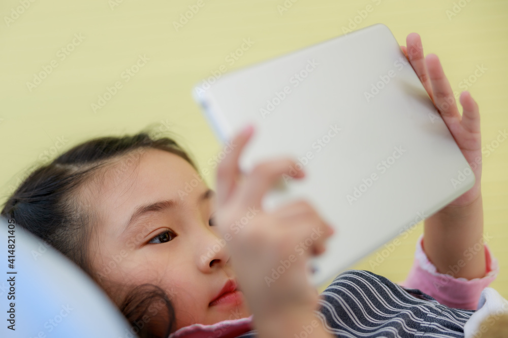 Girl playing game on tablet computer