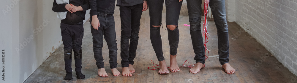 Family look bare feet wearing black outfit on wooden floor. Legs shot, closeup, modern fashion stylish closing, blogging concept. Long size horizontal photo Family look bare feet wearing black outfit on wooden floor. Legs shot, closeup, modern fashion stylish closing, blogging concept. Long size horizontal photo