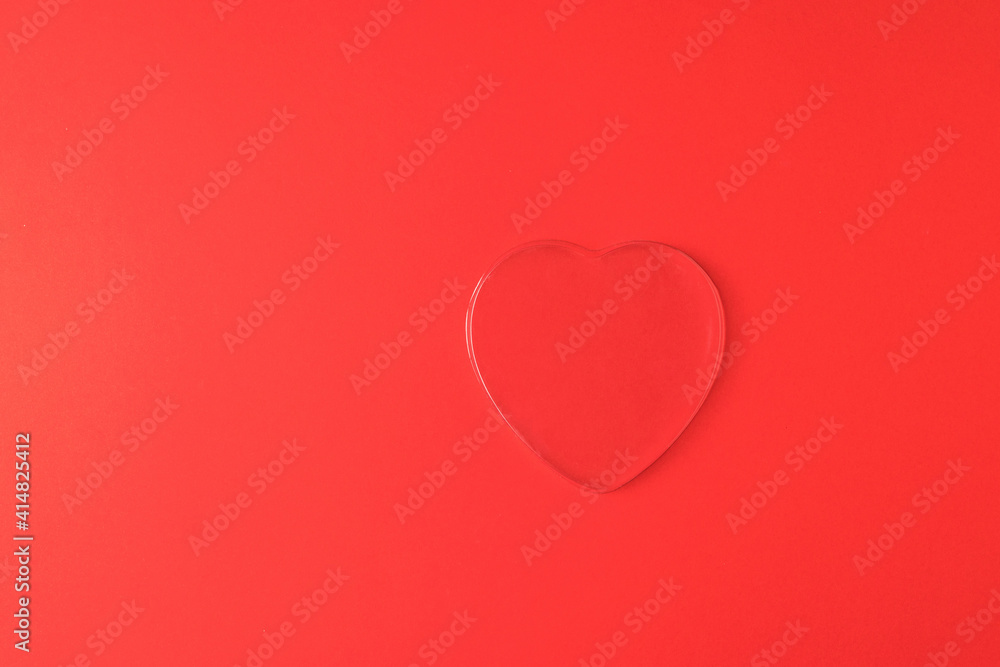 A large transparent heart on a bright red background.