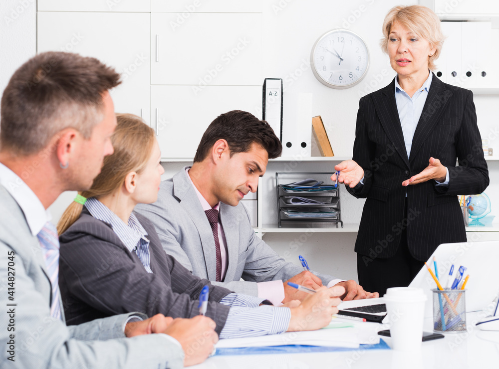Fototapeta premium Successful business woman holding meeting with colleagues in office