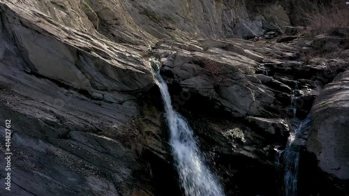 Close drone flight over water in near of a waterfall at daytime photo