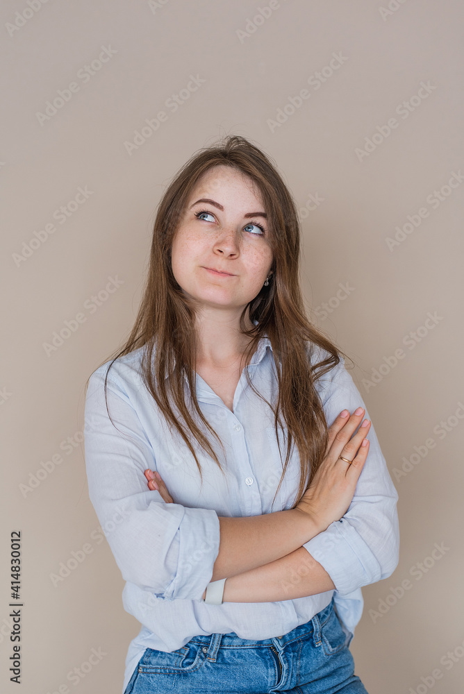 Young girl isolated on beige background shows standing thoughtfully Young girl isolated on beige background shows standing thoughtfully