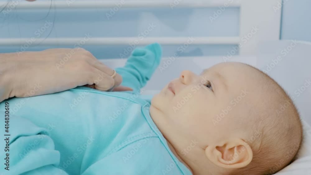 Happy mom touches a newborn baby's nose with her finger. The child laughs and plays. close-up Happy mom touches a newborn baby's nose with her finger. The child laughs and plays. close-up