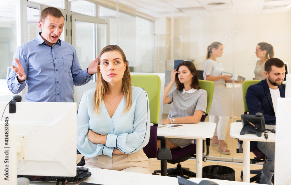 Irritated boss scolding unhappy female subordinate pointing out shortcomings and misses in work