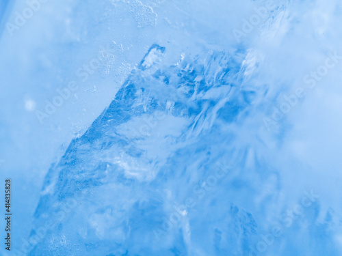Macro view to ice texture. Close up shot. Soft focus. Blue background.